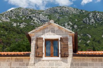 Old house facade fragment with attic window. Perast, Montenegro