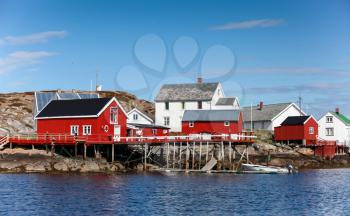 Traditional Norwegian village with red and white wooden houses on rocky coast