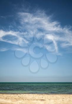 Beautiful cloudy sky over white sandy beach. Vertical photo background