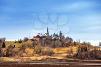 Traditional Norwegian Lutheran Church in small village on the hill