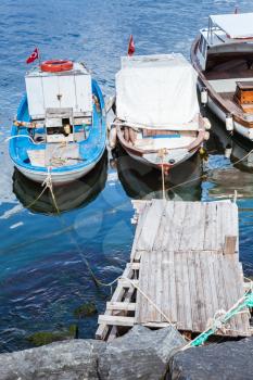Colorful wooden fishing and pleasure boats moored in small port of Avcilar, district of Istanbul, Turkey. Vertical photo
