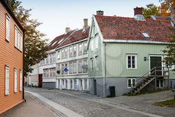 Traditional Scandinavian wooden houses stand along old street in Trondheim, Norway