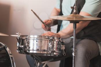 Live music background, drummer plays on a snare drum an cymbals, close-up photo with selective soft focus