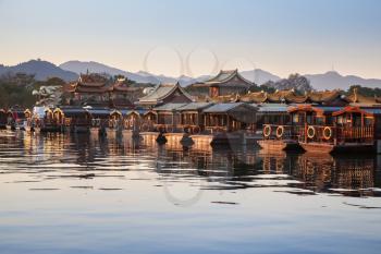 Traditional Chinese wooden recreation boats are moored along West Lake coast. Famous park in Hangzhou city, China