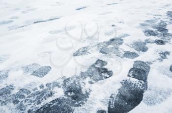 Footprints in ice-crushed ground on a winter street