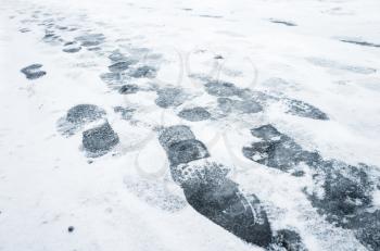 Footprints in wet fresh snow on a urban street