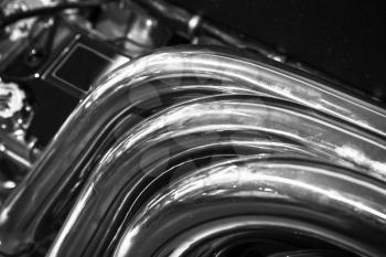 Chromed exhaust pipes. Shiny motor parts, V12 engine fragment, closeup photo with selective focus