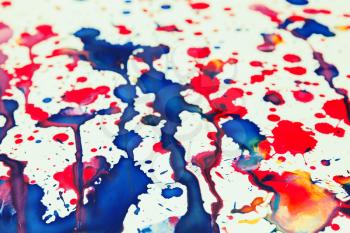 Colorful paint splashes artistic pattern over white paper, toned background photo texture