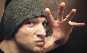 Young aggressive Caucasian man threatens with fingers. Close Up studio face portrait, selective focus