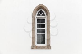 Window in white stone wall, Gothic Revival architecture style. Background photo texture