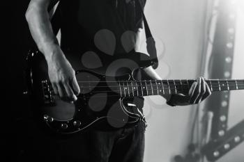 Hands of a bass guitar player, live music theme, black and white