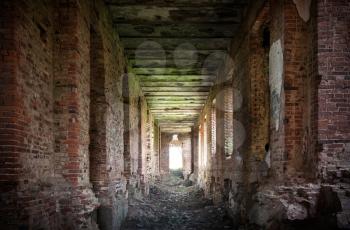 Abandoned landmark interior with dark corridor: ruins of old military quarters. Was built in 6 years from 1818. Architect - Vasily Petrovich Stasov. Selishi village, Novgorod region, Russia