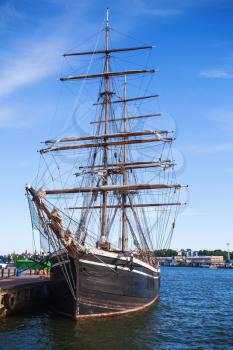 Vintage black brig stands moored in Helsinki port, old wooden sailing ship