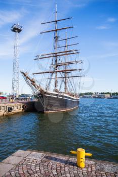 Vintage brig stands moored in Helsinki port, old wooden sailing ship