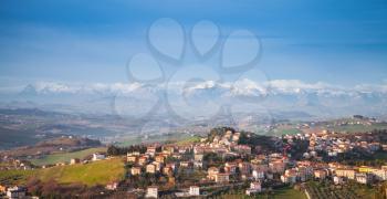 Province of Fermo, Italy. Panoramic landscape of Italian countryside. Village on hills under blue sky