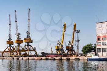 Yellow port cranes stand on the pier in Burgas harbor. Black Sea coast, Bulgaria