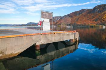 Concrete pier with Lifebuoy in Kyrksaeterora town. Rural Norwegian landscape at autumn day