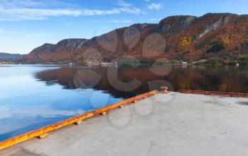 Concrete pier for ferry mooring operations in Kyrksaeterora town. Rural Norwegian landscape at autumn day