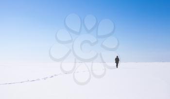 Lonely girl walks along the endless snowfield, Russian winter landscape