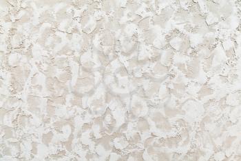 Beige wall with white decorative relief stucco pattern, background photo texture