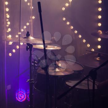 Live rock music photo background, rock drum set  with cymbals in stage lights. Close-up square photo, soft selective focus