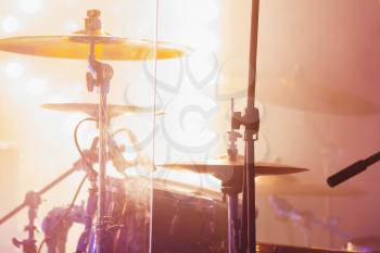 Live rock music photo background, rock drum set  with cymbals in bright strobe  lights. Close-up photo, soft selective focus