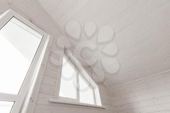 Empty new wooden house interior fragment, white attic room with window and balcony door