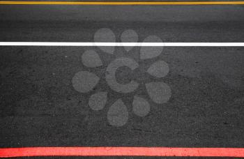 Highway road marking. Yellow, white and red lines over dark asphalt. Background photo