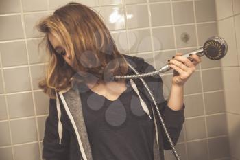 Stressed sad European teenage girl with shower. Depression mood concept. Vintage tonal correction photo filter