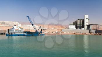 Dredging works in new Aqaba port, Jordan. Blue deck cargo ship