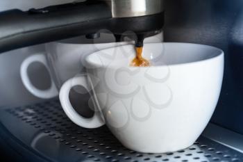 White ceramic cups in the coffee machine.