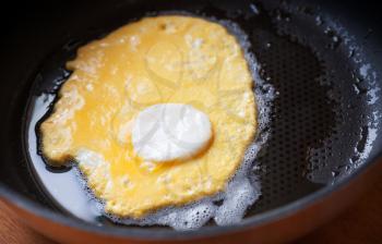 Original roasted eggs with white center in black pan