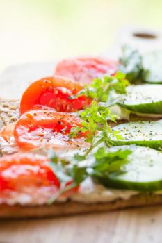 Healthy food, bright breakfast sandwiches. Finnish rye crisp bread, soft cheese, cucumber, tomato, parsley and black pepper