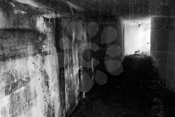 Empty abandoned bunker interior with glowing end of dark corridor, green toning photo filter effect