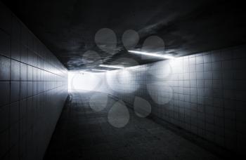 Underground passage with lights and glowing end