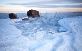 Winter landscape with ice and stones on frozen Baltic Sea