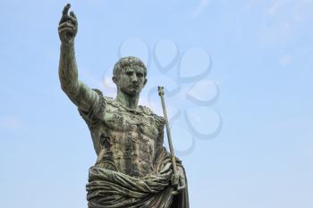 Ancient statue over blue sky. S.P.Q.R. IMP CAESAR Augustus PATRIAE PATER. Via dei Fori Imperiali street, Rome, Italy