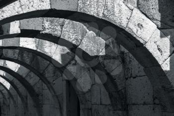 Dark stone corridor with arches. Ruins of Ancient city Smyrna. Izmir, Turkey. Monochrome photo