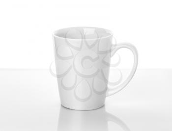 White ceramic cup stands on table above white background