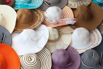 Colorful female summer hats lie on the counter
