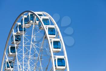 Ferris wheel over clear blue sky background