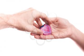 Pink painted handmade heart shaped stone as a gift in man's hand isolated on white