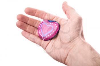 Handmade pink painted heart shaped stone as a gift in man's hand isolated on white