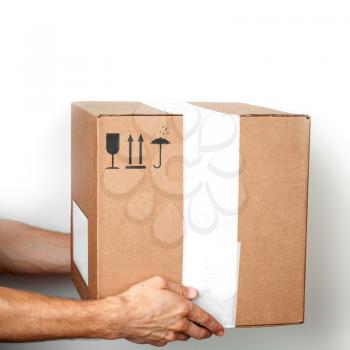Cardboard box with standard black signs in male hands on white background