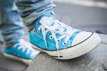 Brand new blue shoes, urban walking theme. Closeup photo with selective focus and shallow DOF