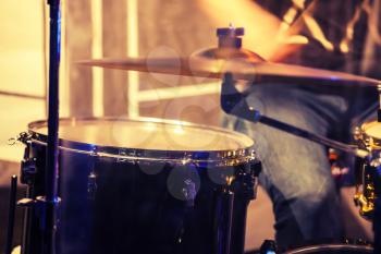 Vintage toned rock music blurred photo background, drummer on a stage