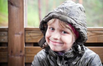 Portrait of a smiling little blond girl  in a casual jacket with the hood