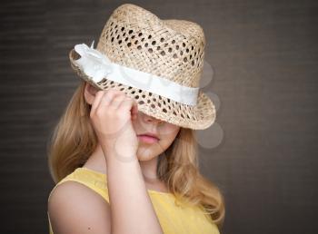 Portrait of a little blond girl with straw hat