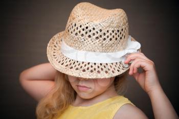 Closeup portrait of a little blond girl with straw hat
