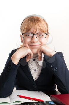 Little blond schoolgirl with glasses smiles above white